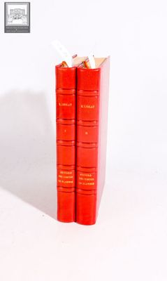 two red books sitting on top of each other on a white surface
