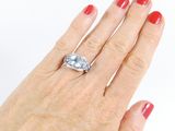 a woman ' s hand holding a ring with a diamond on it