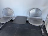 trois chaises placées les unes à côté des autres sur un sol carrelé