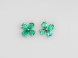 a pair of emerald earrings on a white background