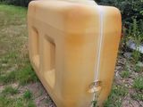 a large yellow water tank sitting in the middle of a field