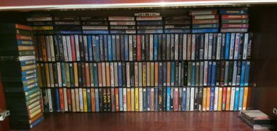 a book shelf full of dvd ' s in a room