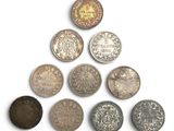 plusieurs types de pièces de monnaie sont disposés sur une surface blanche