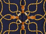 a close up of a square scarf with ropes and knots on it
