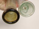 a person holding two empty wine bottles next to each other