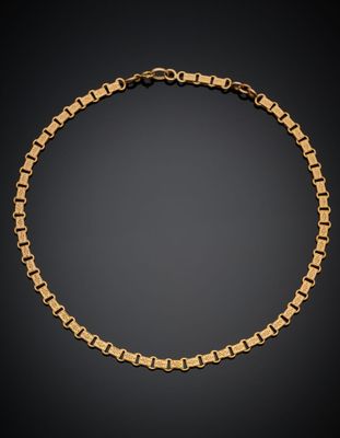 un bracelet en chaîne dorée à maillons carrés sur fond noir