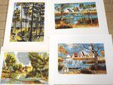 four paintings of different landscapes are displayed on a tile floor