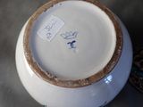 a white bowl with a brown rim and a tag on it