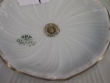 a white plate with a gold rim and a label on it