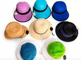 Plusieurs chapeaux sont disposés en cercle sur une surface blanche