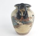a vase with a handle on it that has a picture of a village on it