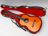 une guitare dans son étui, posée sur une table