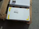 un réfrigérateur blanc posé sur une palette dans un entrepôt