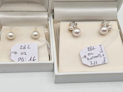 three pairs of pearl earrings in a box with price tags on them
