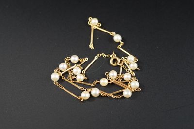 un gros plan d'un bracelet orné de perles sur un fond noir