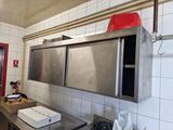 une grande cuisine avec de nombreux plans de travail en inox