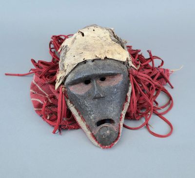 un masque entouré d'un cordon rouge sur un fond gris