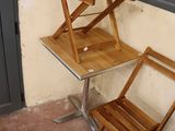 two wooden chairs and a table on the porch