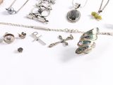 many different types of jewelry displayed on a white surface