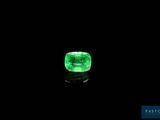 a green emerald stone on a black surface