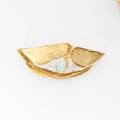 a gold plate with a green stone in it
