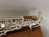 a silver saxophone sitting on top of a brown box
