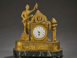 une horloge en or surmontée d'une statue