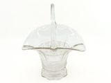 a glass vase with a spoon in it on a white surface