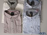 three men ' s shirts wrapped in plastic on a table