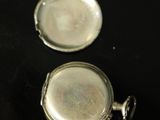 two pieces of silver that are on a black surface