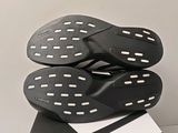 the soles of a pair of black and white shoes are stacked on top of each other
