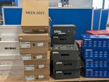 Plusieurs cartons de vêtements pour hommes sont empilés sur une étagère dans un magasin.