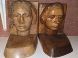 two wooden sculptures of a man and a woman on a shelf