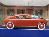 une petite voiture rouge avec un homme assis à l'intérieur