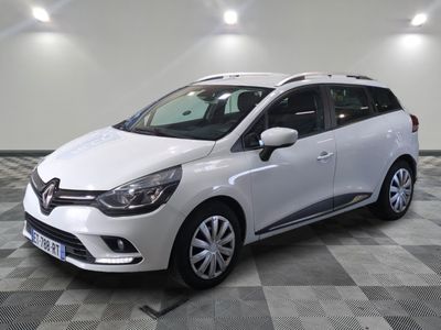 la voiture blanche est garée sur un sol en damier dans le garage