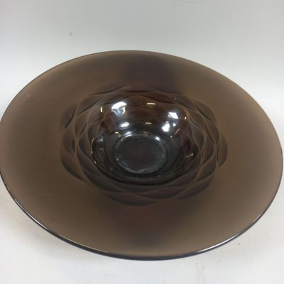 a glass bowl on a plate on a white table