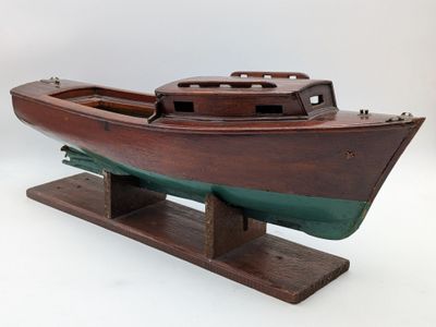 une maquette en bois d'un bateau posée sur un socle