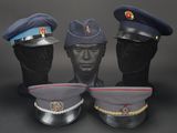 three military hats on a mannequin head on a black background