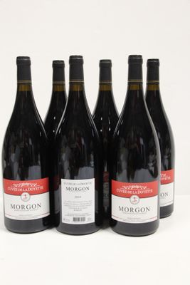 six bottles of red wine are lined up on a white surface
