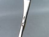 a spoon with a toothbrush in it sitting on a table