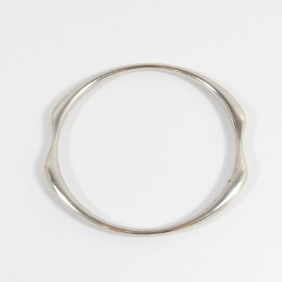 gros plan d'une bague en argent sur une surface blanche