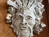 a statue of a man with grapes on his head