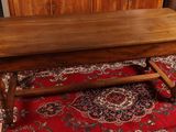 a wooden table on a red rug in a room