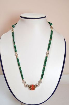 collier de perles vertes et rouges sur un mannequin blanc