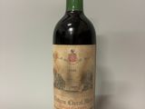 une vieille bouteille de vin posée sur une table blanche