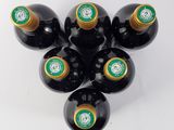 six bottles of wine are arranged in a circle on a white surface