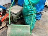une poubelle verte posée à côté d'un tas d'ordures