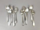six silver spoons and a spoon with a tag on them