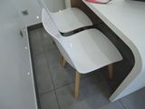 a white desk with two chairs and a laptop on it