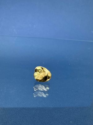 une pièce d'or posée sur une table bleue